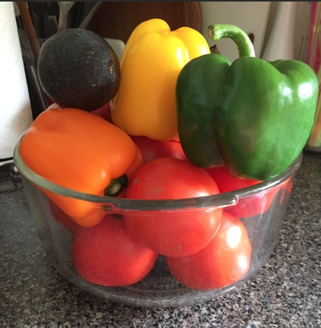 Bowl of fresh tomatoes, bell peppers and avocado 