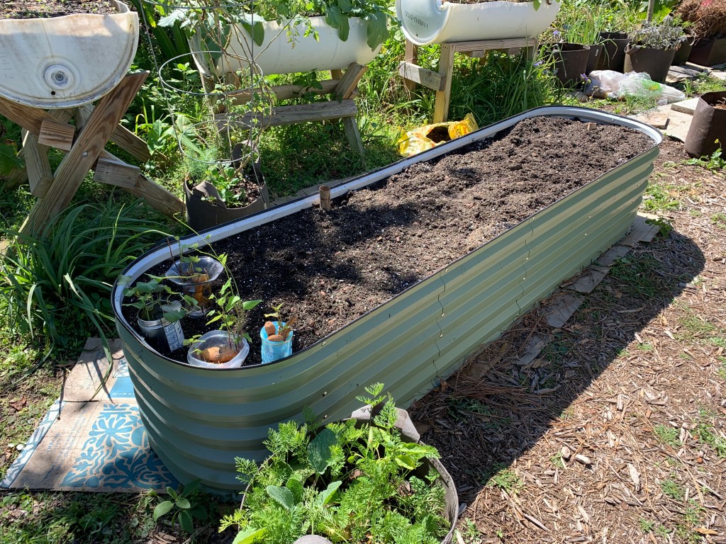 metal raised bed is filled with dirt.