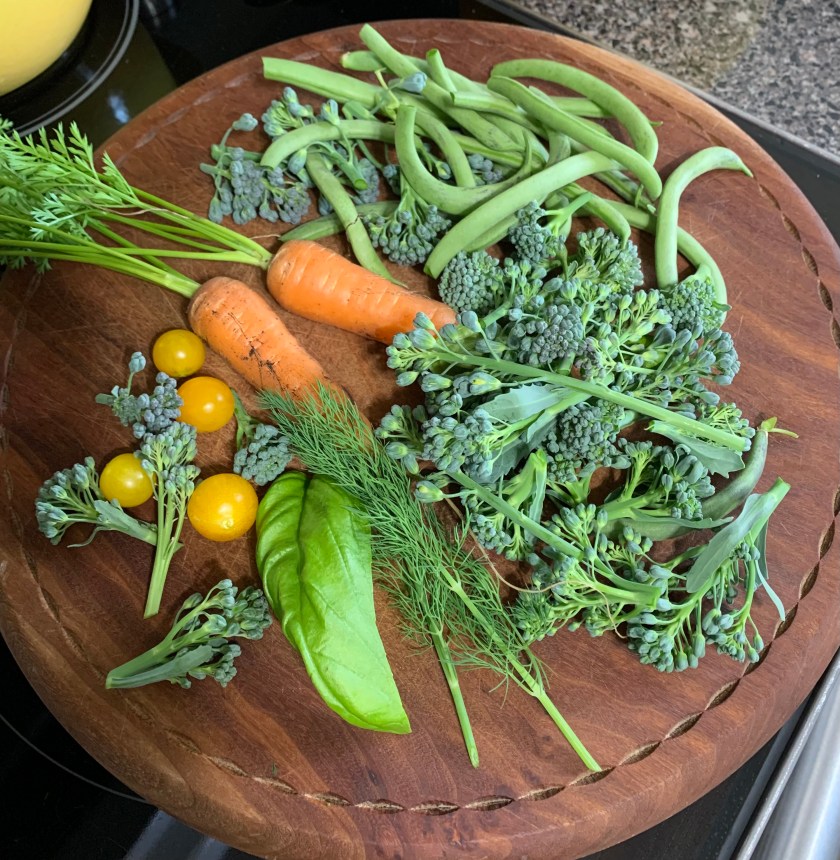 fresh picked garden vegetables on wood cutting board