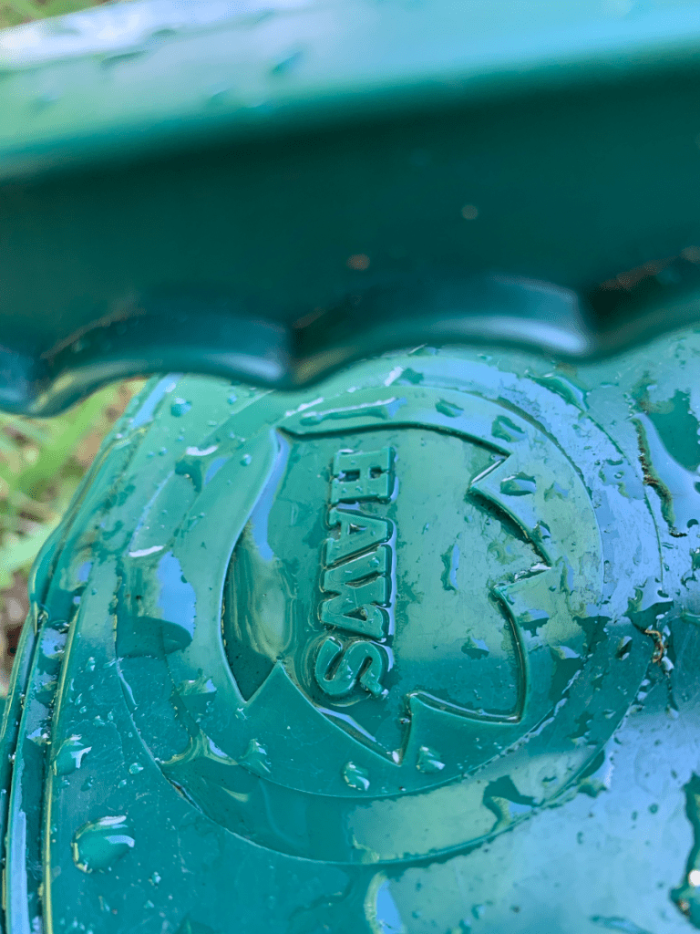 Haws name imprinted on green plastic watering can.