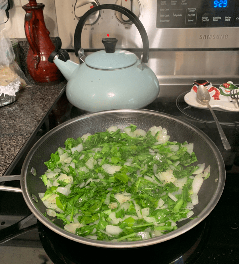 Cooking chopped greens from the Daikons with onions.